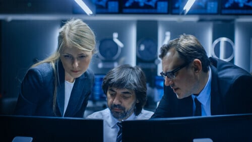 Three people looking at a computer 